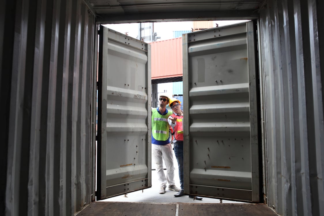 Worker inspecting cargo shipping containers. before departure.